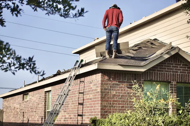 Professional roofer working on a residential roof in Corinth